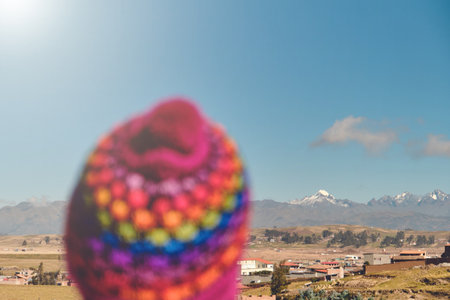 Back view of young traveler in hat standing over mountain peaks. Autumn traveling scene, wanderlust concept.の写真素材