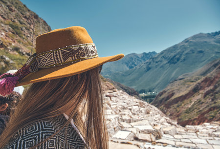 Traveler hipster girl in hat and poncho exploring Maras Salt Mines, Peru. travel and wanderlust concept.の写真素材
