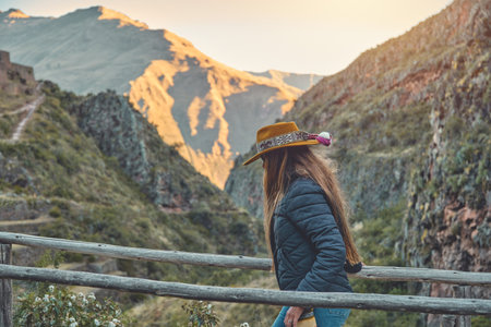 traveler hipster girl in hat with backpack exploring Pisac Archaeological of Peru.
