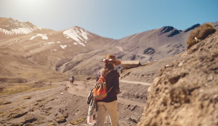 traveler hipster girl in hat with backpack exploring sunny peruvian andes, South Americaの写真素材
