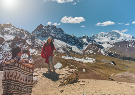 Young photographing on phone beautiful landscapes, traveling highly in the mountains on Ausangate...