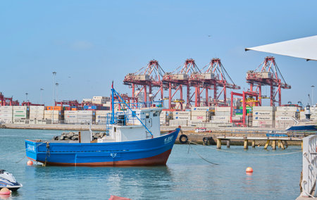 Callao, Peru - january 4 2024. Small fishing boat near dock and containers in the port of Callao.のeditorial素材