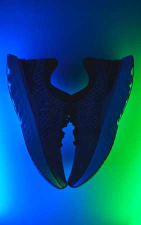 Running sneakers isolated on a Neon lights. Concept healthy lifestyle outfit, sport and diet. Flat...
