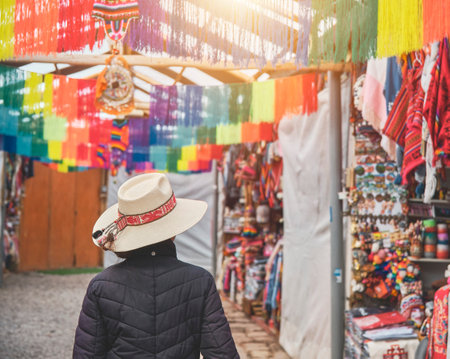 Young woman traveler in hat walks through market typical city in Cusco, Peru. Copy spaceの写真素材