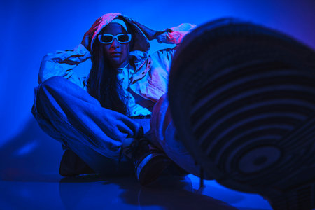 A woman is sitting on the floor with her feet up