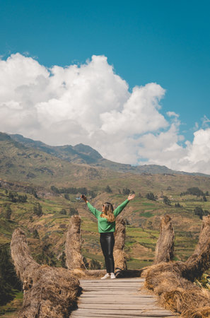 A woman in a green sweater is standing on a viewpoint in Canta, Lima, Peru.