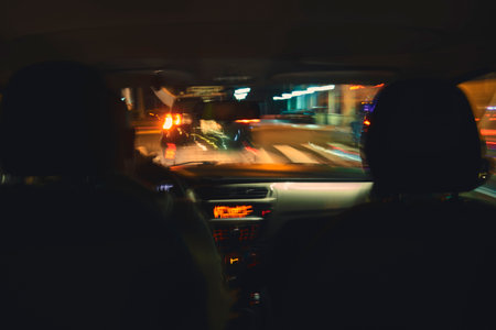 A blurry image of a car with two people in the front seatの写真素材