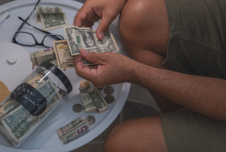 A man is holding a jar full of money and coins. New home concept.の写真素材