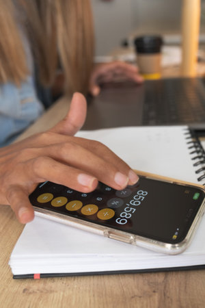 A woman is using a calculator on her phone