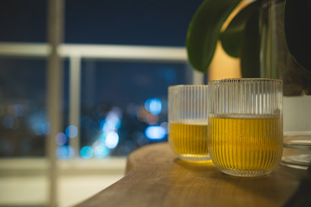 Two glasses of beer on a table with a view of the city