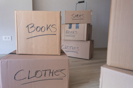 A stack of boxes with the words books and clothes written on them. New house concept.の写真素材