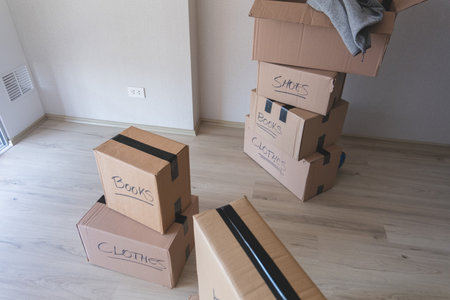 A stack of cardboard boxes with the word written on the top. New house concept.