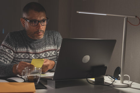 A man is sitting at a desk with a laptop and a cup of coffee. Remote work conceptの写真素材