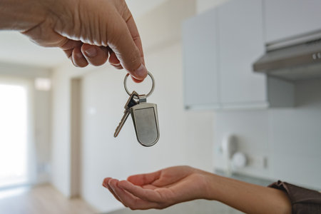 A man is handing a key to a woman. New home concept.の写真素材