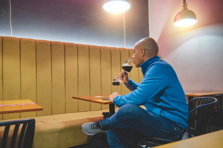 A man enjoying craft beer at a cozy bar.の写真素材