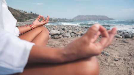 Close up to woman meditating on beach, enjoying summer relaxation and mindfulness by the seaの写真素材