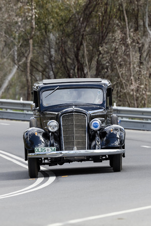 Adelaide, Australia - September 25, 2016: Vintage 1934 Oldsmobile Sedan driving on country roads near the town of Birdwood, South Australia.のeditorial素材
