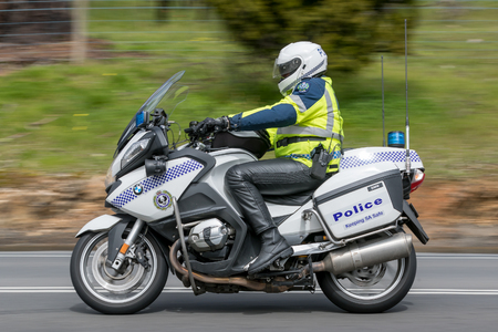 Adelaide, Australia - September 25, 2016: South Australian Police officer riding a BWM Police motorcycle on country roads near the town of Birdwood, South Australia.のeditorial素材