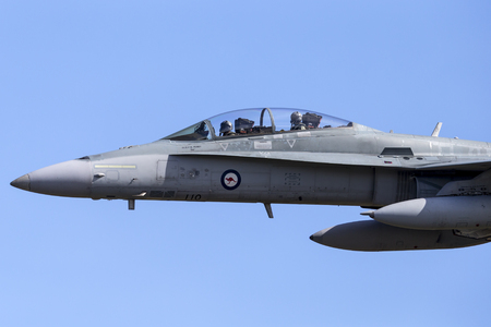 Albion Park, Australia - May 4, 2014: Royal Australian Air Force (RAAF) McDonnell Douglas F/A-18B Hornet jet aircraft A21-110 flying against a blue sky.のeditorial素材