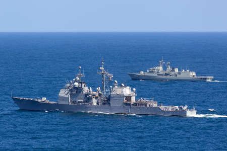 Sydney, Australia - October 11, 2013: USS Chosin (CG-65) Ticonderoga-class guided-missile cruiser and Royal Australian Navy Anzac-class frigate HMAS Parramatta sailing at sea.のeditorial素材