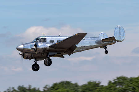 RAF Fairford, Gloucestershire, UK - July 10, 2014: Vintage Beech G18S N45CF twin engine aircraft with highly polished natural metal finish.のeditorial素材