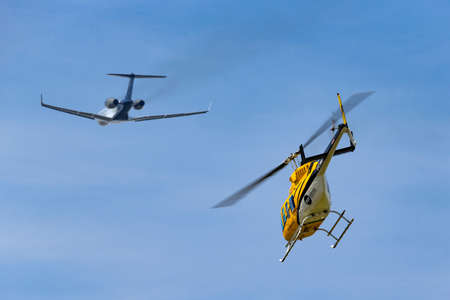 Farnborough, UK - July 18, 2014: Elite Helicopters Bell 206L-1 LongRanger II G-LIMO helicopter taking off with a business jet in the background.のeditorial素材