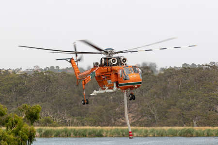 Bundoora, Australia - December 30, 2019: Erickson Air Crane helicopter taking off after filling with a load of water to fight a fire.のeditorial素材