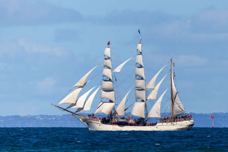 Historic clipper sailing ship on open blue water in full sail.のeditorial素材
