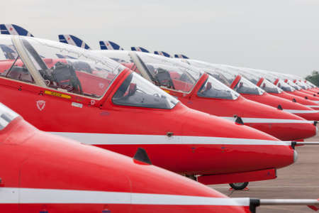 RAF Fairford, Gloucestershire, UK - July 11, 2014: Royal Air Force (RAF) Red Arrows formation aerobatic display team British Aerospace Hawk T.1 Jet trainer aircraft parked in a line.のeditorial素材