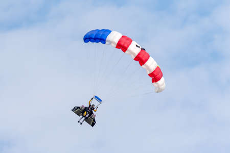 Payerne, Switzerland - August 29, 2014: Yves Rossy also know as Jetman parachutes to the ground after flying with his jet powered wing on his back.のeditorial素材