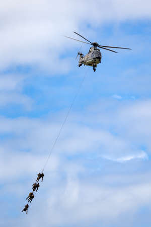 Payerne, Switzerland - August 30, 2014: Swiss Air Force Aerospatiale AS532 (TH98) military utility helicopter T-340 transporting troops by rope suspension.のeditorial素材