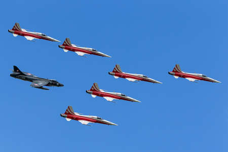 Payerne, Switzerland - September 1, 2014: Patrouille Suisse formation display team of the Swiss Air Force flying in formation with a Hawker Hunter aircraft that was a former aircraft used by the team.のeditorial素材