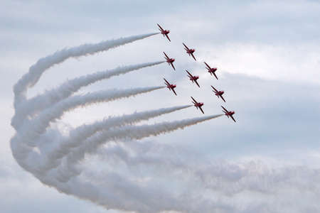 RAF Waddington, Lincolnshire, UK - July 6, 2014: Royal Air Force (RAF) Red Arrows formation aerobatic display team flying British Aerospace Hawk T.1 Jet trainer aircraft.のeditorial素材