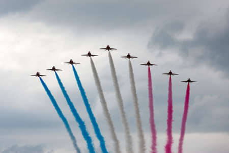 RAF Waddington, Lincolnshire, UK - July 6, 2014: Royal Air Force (RAF) Red Arrows formation aerobatic display team flying British Aerospace Hawk T.1 Jet trainer aircraft.のeditorial素材