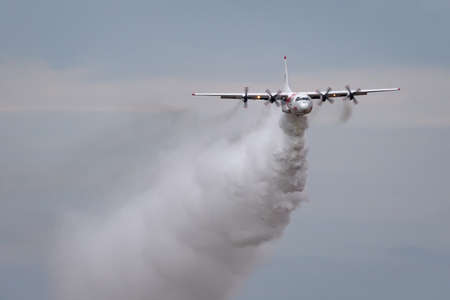 Avalon, Australia - February 27, 2015: Coulson Aviation Lockheed EC-130Q large aerial fire fighting aircraft N130FF dropping a load of water.のeditorial素材