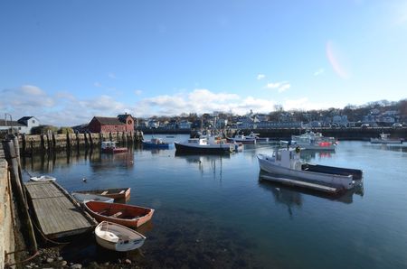 Low tide in the harbor with old rowboats in front of a red lobster shackの写真素材