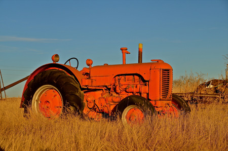 Old orange tractor parked int he fieldの写真素材