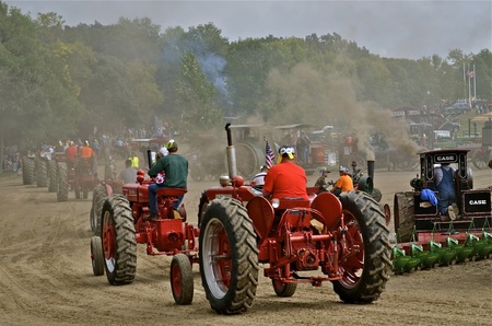 Tractors line up for a parade in the smoke and dust at a steam threshers reunionのeditorial素材