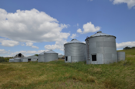 Empty metal grain bins on an abandoned farmの写真素材