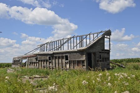 Skeletal remains of a disintegrating barn on an a farm settingの写真素材