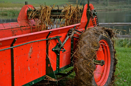 A refurbished red manure spreader has been very recently usedの写真素材