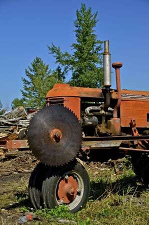 Mounted circular saw on a tractor is used for cutting logs into firewood chucksの写真素材