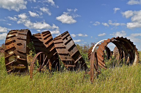 Huge steam engine engine wheels piled together in a fieldの写真素材