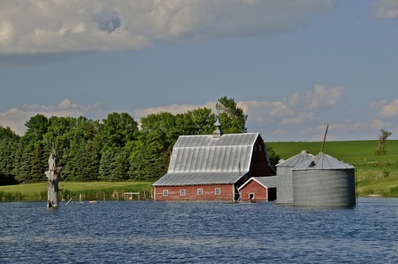 Rising lake levels floods farm building and grain tanksの写真素材