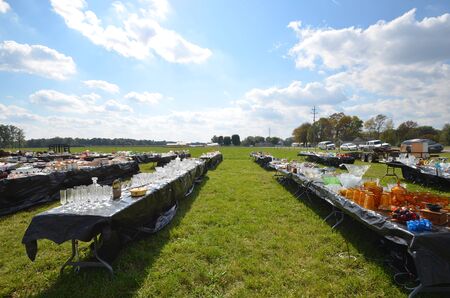 Cars are lined up on the highway waiting for the opening of a flea market full of glassware...