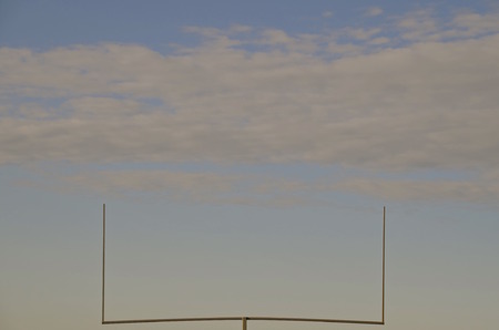 Football field goal uprights silhouetted in the skyの写真素材