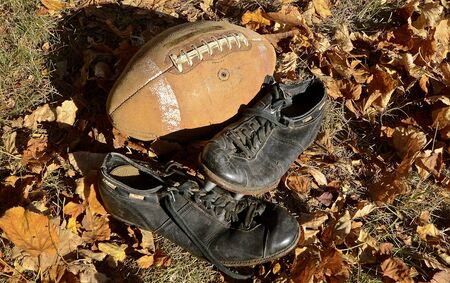 Old football memories with pigskin and spikes on shoesの写真素材