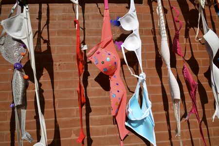 Display of Colored Bras on the wall of a brick building bringing awareness of breast cancer.の写真素材