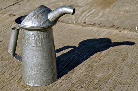 An old galvanized metal quart oil can cast it's shadowの写真素材