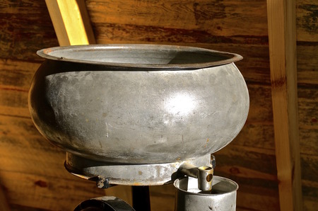 The aluminum supply can or bucket of an old cream separator and the faucet in the loft of a barnの写真素材